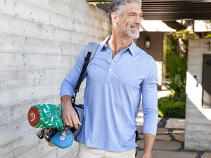 Model wearing Criquet - Brrr Long Sleeve Range Polo in Lapis Blue.