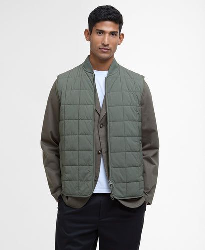 Model wearing Barbour Elmstone Quilted Gilet in Uniform Green.