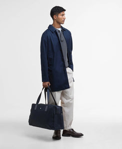 Model holding Barbour Cascade City Holdall Bag in Navy