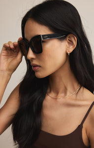 Model wearing ZSupply Confidential Sunglasses in Polished Black - Brown Polarized. 