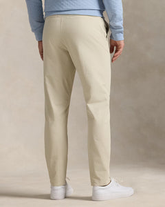 Model wearing  RLX - Ralph Lauren Performance Pant in Sand - back.